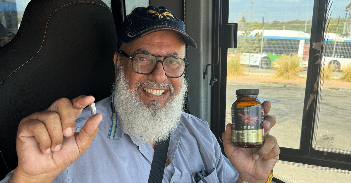 יאיר בועז, נהג אוטובוס ותיק, מחזיק כמוסה ובקבוק של תוסף התזונה ויניה.
