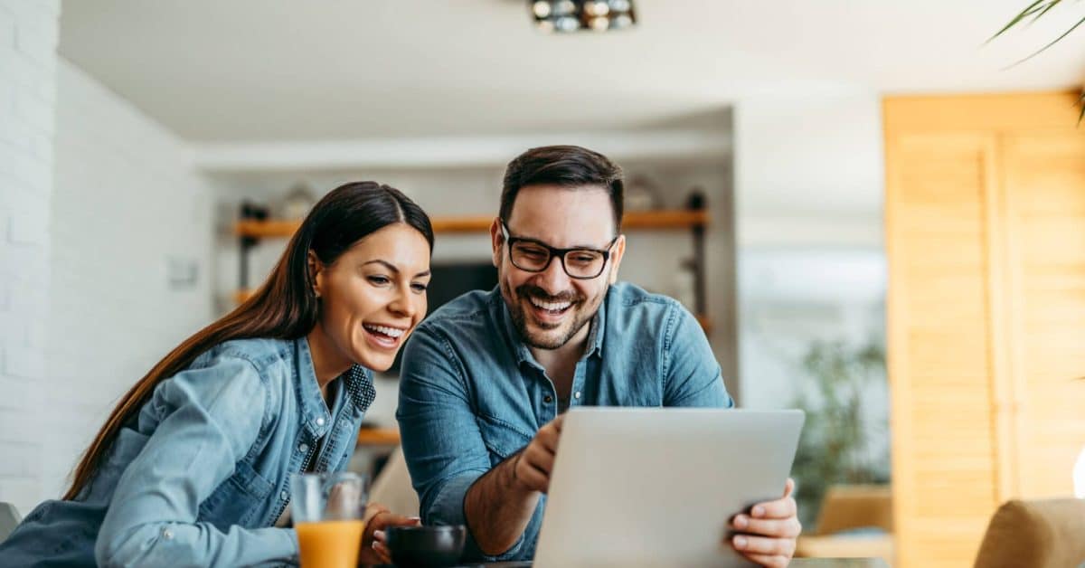 Couple,Looking,At,Laptop,Computer,Together,,At,Home,,Front,View,