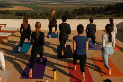 ריטריט יוגה ומדיטציה עם נוף להרים סדנת יוגה קבוצתית בטבע מול נוף הררי עוצר נשימה במסגרת ריטריט יוגה